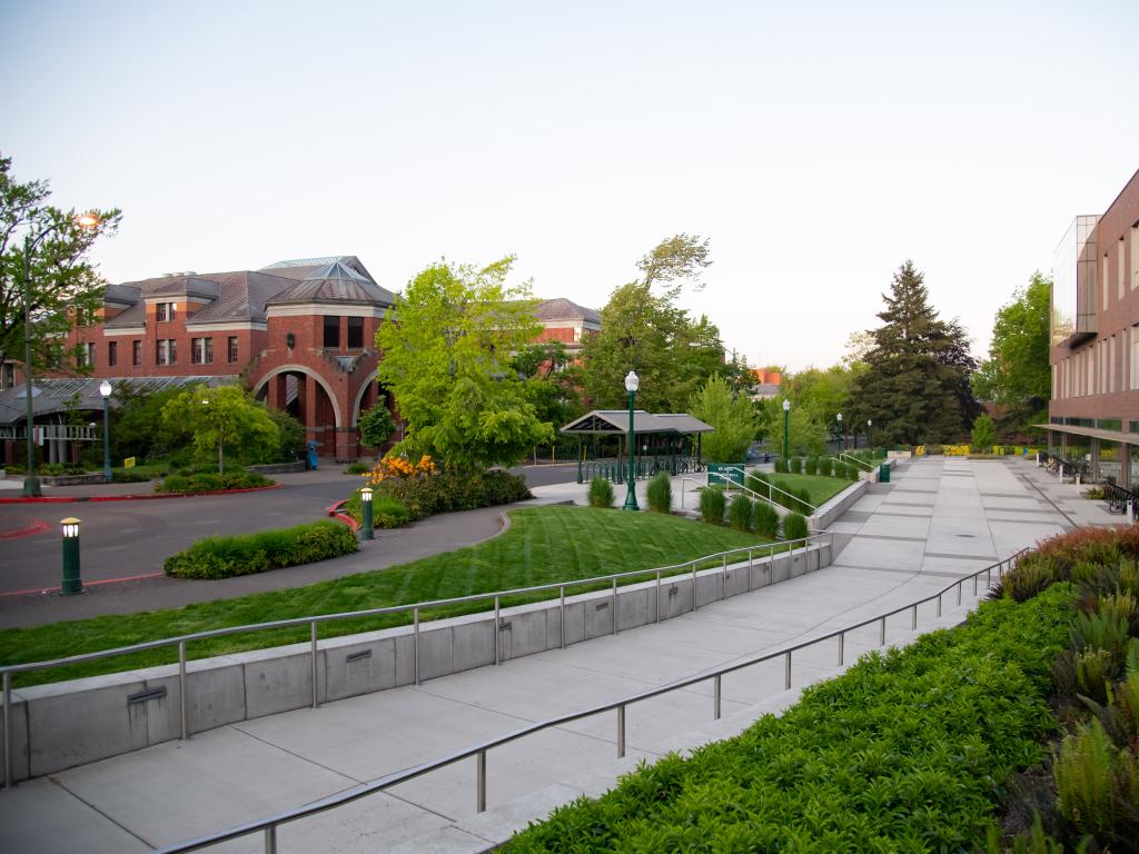 a sidewalk and a street lined with brick buildings