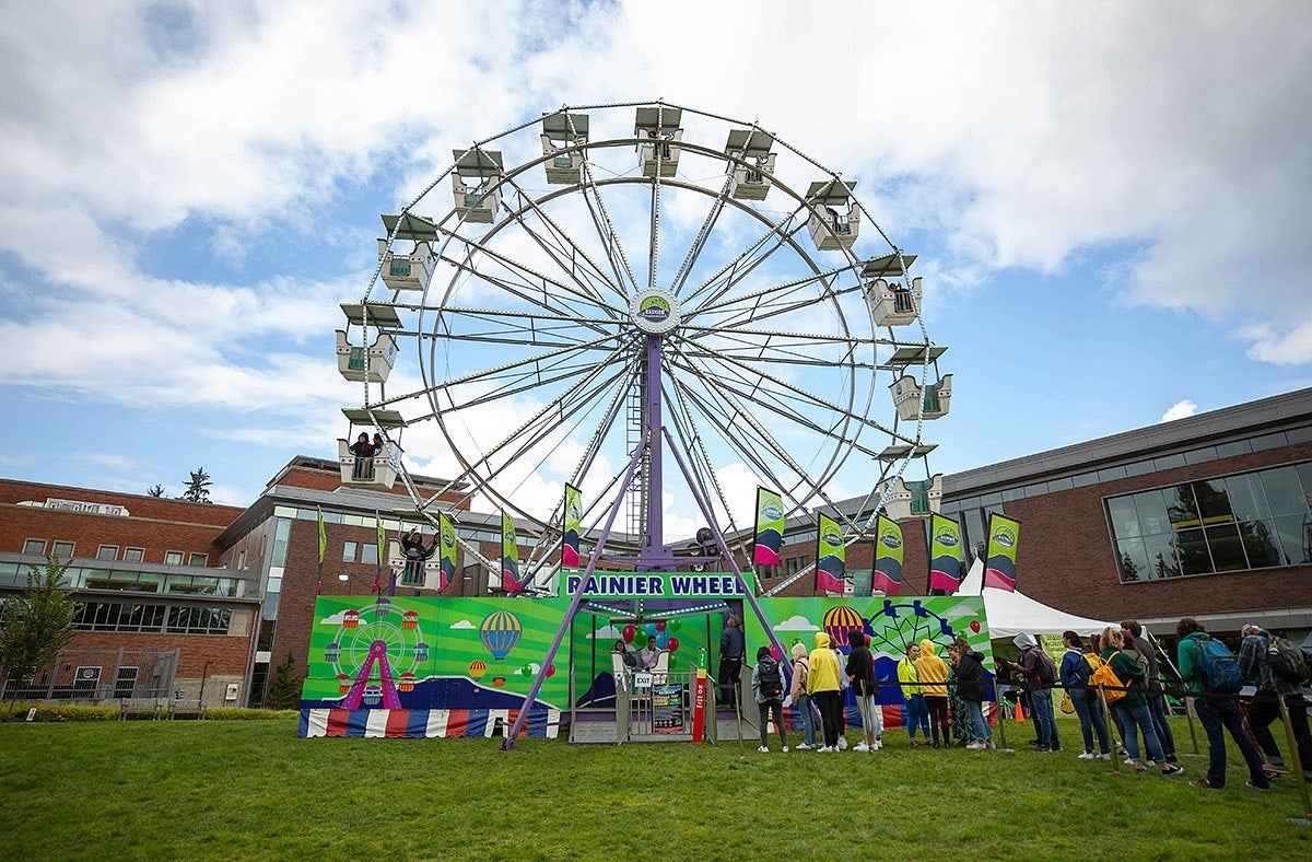 Ferris wheel on campus with line of people waiting 