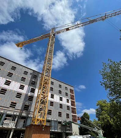 A tower crane is next to a new building under construction.