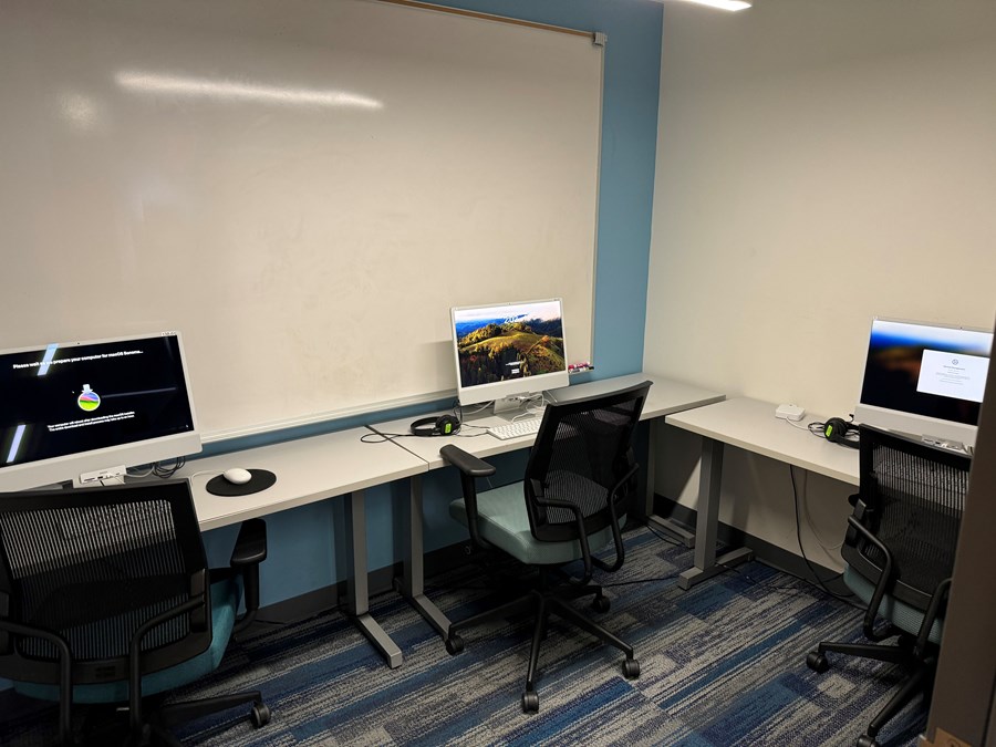 Image of Allen 138 lab with three computers on desks and a whiteboard against the wall