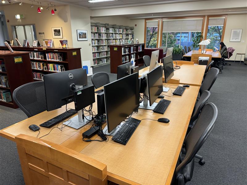 Law Library computers on desks with bookshelves in the background