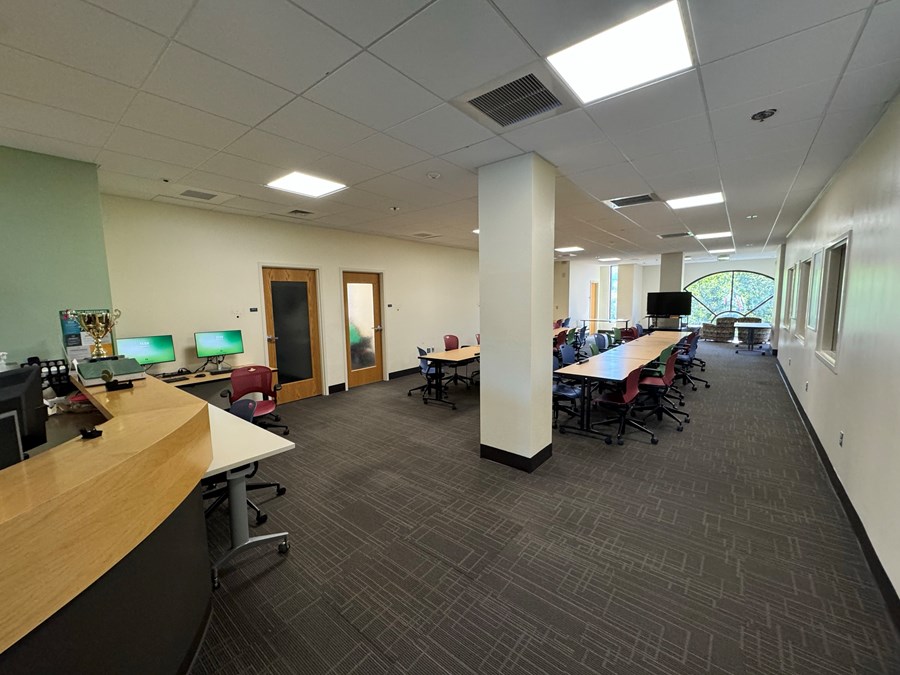 Image of Chiles 326 with two computers to the left, and open space in the middle with desks and chairs
