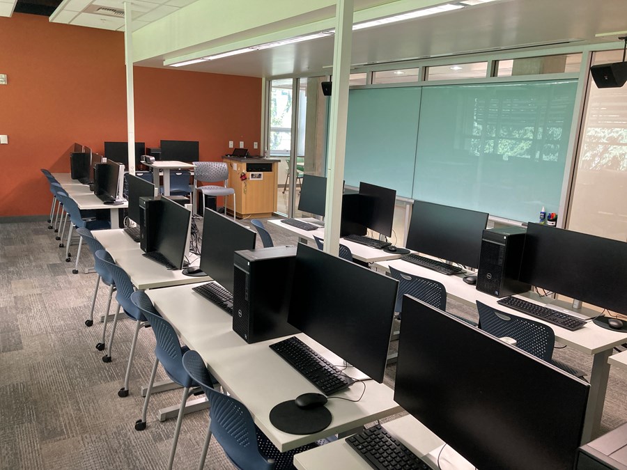 Image of Allen 304 with computers on desks and a whiteboard on the far wall