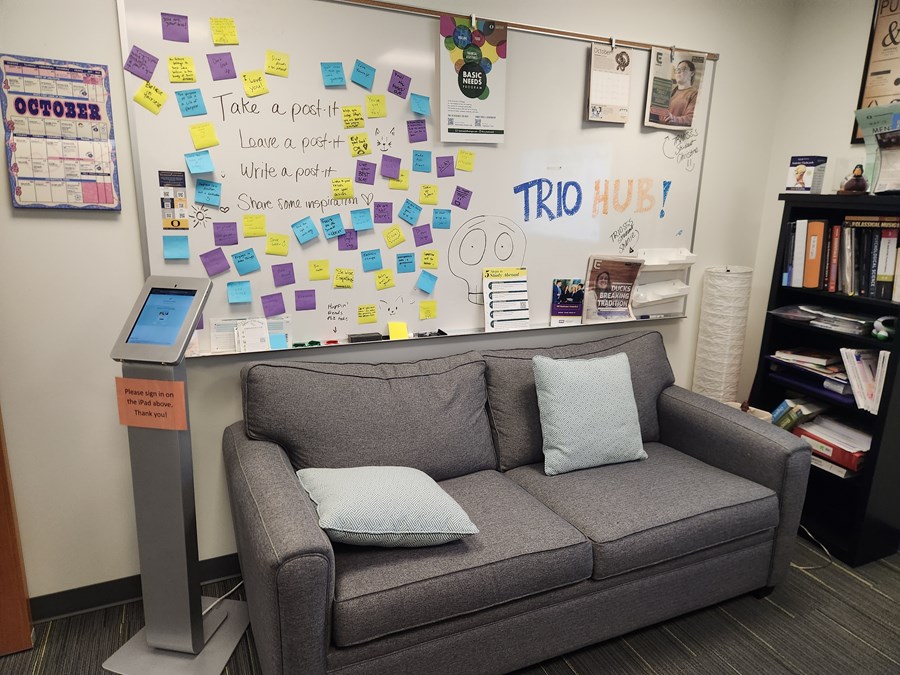 TRIO whiteboard with "Take a post-it, leave a posit- write a post-it" written on the board