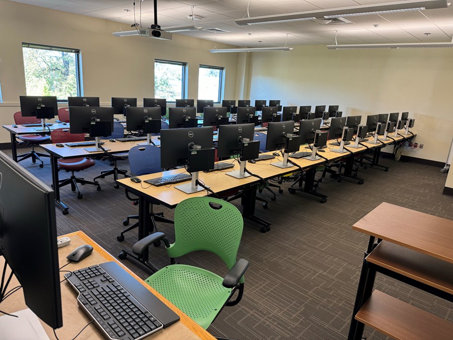 Image of Chiles 323 from the left with the teacher computer in the forefront, and student computer desks in the back