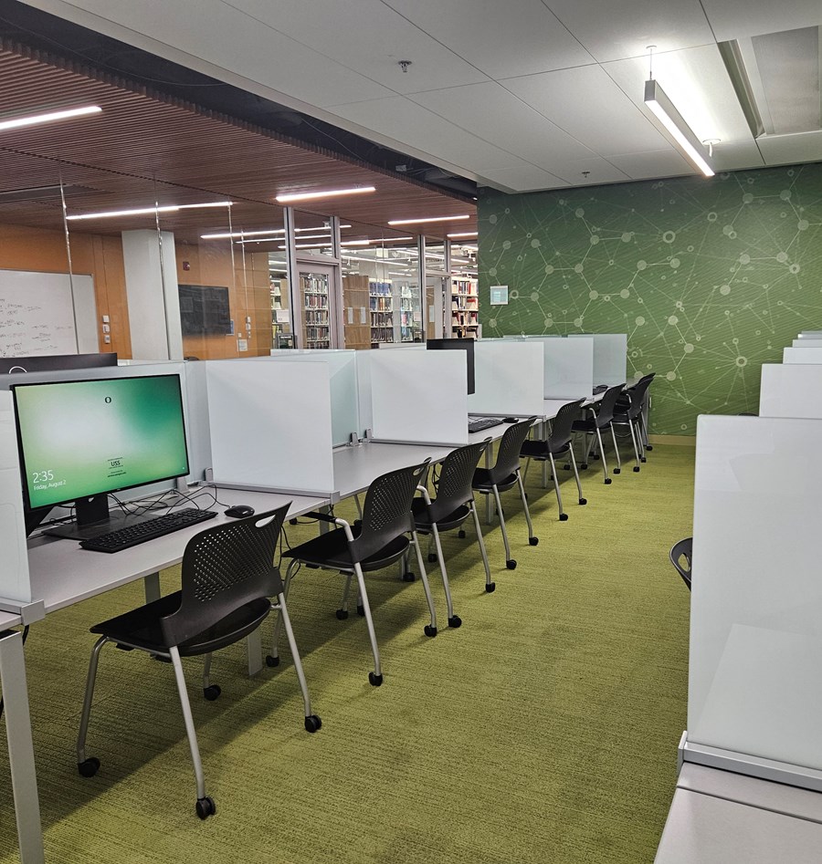 Long desk with computer stations separated by privacy dividers.