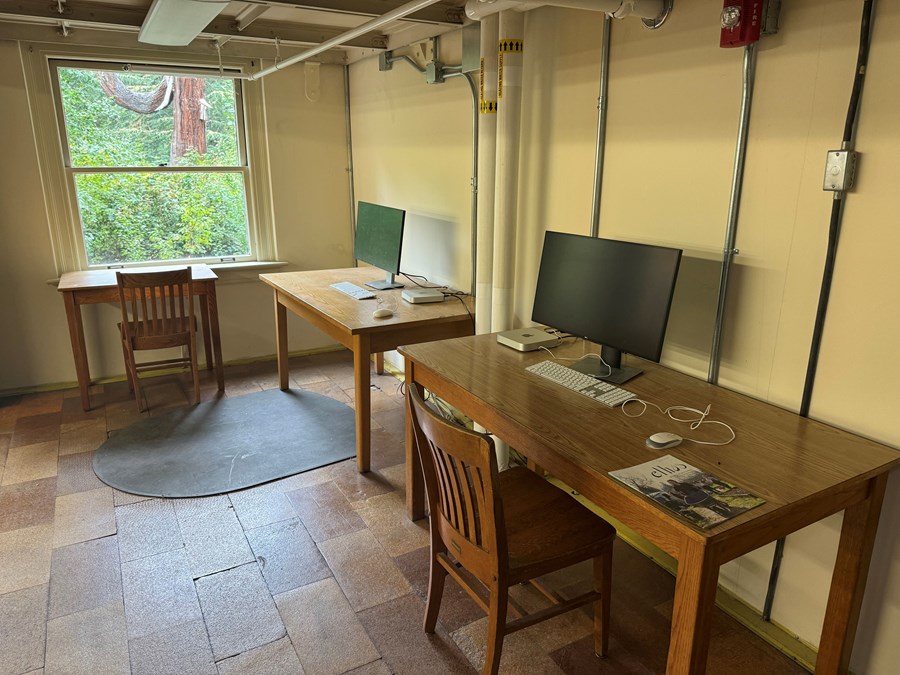 Two Macs on desks within the stacks of the Math Library