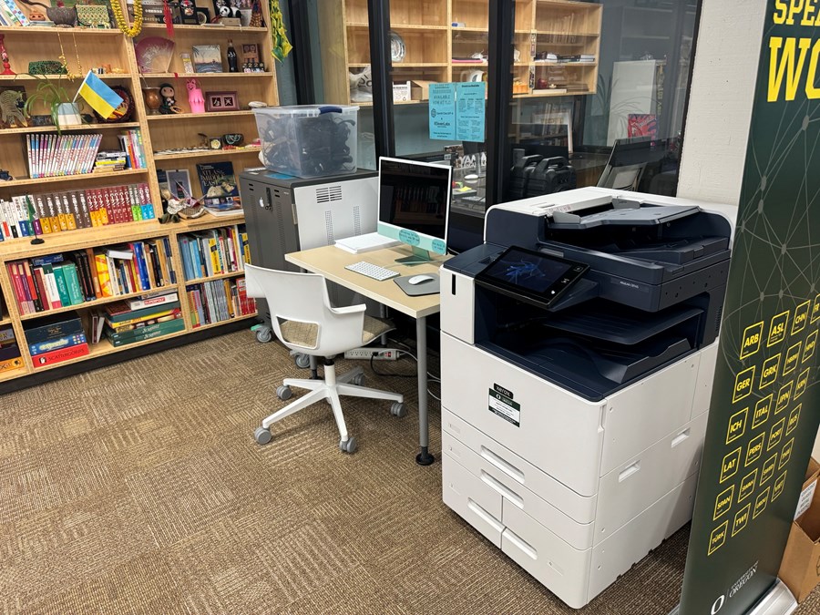 Computer on a desk next to a printer
