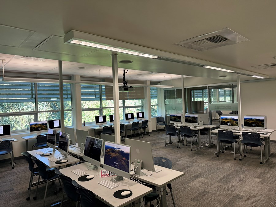 Image of Allen 303 with computers on desks and windows against the back wall