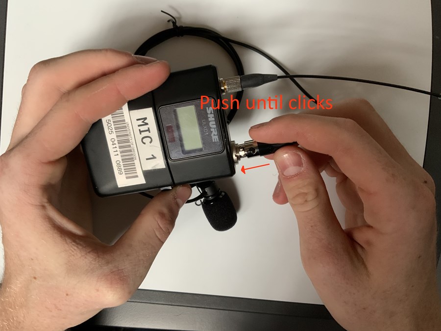Push the mic unit's plug end into the mic pack until the locking button clicks.