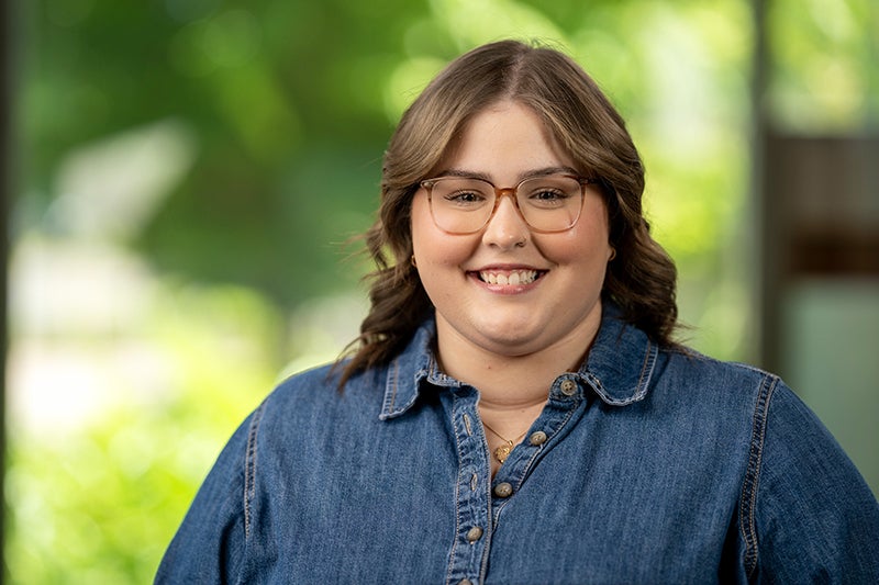 Woman with long brown hair and glasses