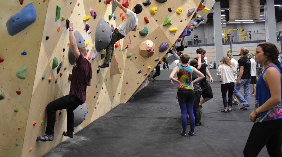 Students climbing on rock wall.